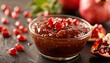 Pomegranate molasses and ripe fruit in bowl with sour sauce, fresh whole and split fruit on table