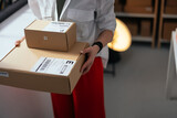 Fototapeta Tulipany - Entrepreneur holding parcels in a modern office