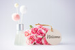Welcome paper tag with fragrance diffuser and pink flowers