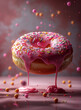 Frosted sprinkled donut on pink background.