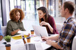 © peopleimages.com - Office, brainstorming and business people in meeting, planning and cooperation with laptop, documents and speaking. Design agency, staff or group with technology, paperwork and collaboration for idea