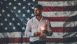 © yurakrasil - A man is holding a sparkler in front of an American flag