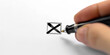 close up a pen writing on paper with cross marks icon isolated white background,cancel symbol	
