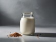 Glass jar filled with milk takes center stage in this composition, set against backdrop that transitions from shadow to light. Milk, with its creamy texture, softly illuminated.