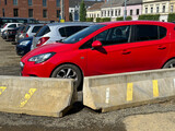 Fototapeta Do pokoju - Cars in the parking lot behind concrete barricades