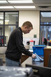© Emanuel - Custodial staff member wiping down a desk surface with a cleaning cloth in an office environment