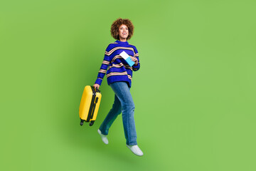 Canvas Print - Photo of positive nice woman tourist hold valise tickets walk hotel empty space isolated on green color background