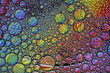 Burbujas de agua y jabón flotan sobre una superficie acuática, con luz superficial sobre un fondo bokeh, formando un diseño original multicolor y abstracto para fondos