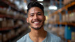 © Nataliia_Trushchenko - A latin man with a beard and a smile is standing in a warehouse. He is wearing a gray shirt and is smiling at the camera. handsome latin man smiling in a warehouse looking directly into the camera
