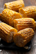 Slate tray with Pieces of Grilled corn on the cob on kitchen table healthy food background