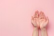 Close-up of hands with palms up, set against a light or pink background. Ample empty space on the right for text or additional elements. 