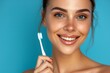 Positive portrait of woman cleaning teeth in studio for gingivitis, dental care, and sustainable cosmetics on blue background. Brushing lips with bamboo toothbrush for dental hygiene or grin