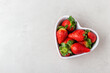 Fresh strawberries in heart bowl with copy space