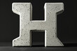 Large concrete letter H on dark background, abstract image