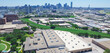 Panorama aerial view hotel swimming pool complex, lush green park, Turtle Creek and dense of industrial, commercial warehouse property in Stemmons Corridor, downtown Dallas skyline in background