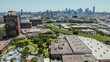 Large outdoor swimming pool complex with downtown Dallas skyline background, Turtle Creek and Trinity River surrounding Stemmons Corridor industrial, commercial property warehouse, aerial view