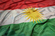 waving colorful national flag of kurdistan on a euro money banknotes background. finance concept.