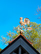 Copper rooster weathervane against blue sky
