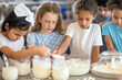 © Eugen - World Milk Day. Children smiling while preparing food in the kitchen. Generative AI