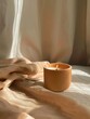 A lit candle on a beige cloth