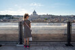 Little girl enjoying the view from the terraces of Sant'Angelo castle overlooking St Peter's Cathedral in Rome, Italy