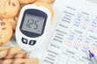 Glucometer with high sugar level, cookies and medical form. Measuring and checking sugar level