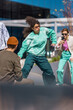 Vertical Screen: Young Stylish Woman Dancing On Street In The Circle of Friends. Female Hip-Hop Dancer Practicing Choreography While Crowd Of Creative People Filming Her On Smartphone For Social Media