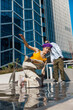 Vertical Screen: Young And Stylish Female Hip-Hop Dancer Freestyling On Street In the Circle Of Fashionable Friends. Group Of Young People Supporting Energetic Performer While She Is Practicing