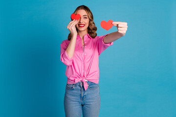 Poster - Photo portrait of pretty young girl hold two little heart postcards wear trendy pink outfit hairdo isolated on blue color background