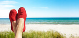 Fototapeta Dmuchawce - Damenbeine mit Roten Stoffschuhen am Strand