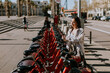 A serene spring afternoon in Barcelona with a smiling woman renting a bicycle