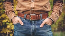   A Tight Shot Of A Man In Jeans And A Brown Shirt, Hands In Pockets