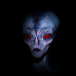 Illustration of a blue skinned alien with bright red eyes in shadows against a dark background.