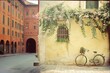 Quaint European Street Scene with a Vintage Bicycle Against an Old Yellow Wall with Cascading Flowers