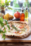 Fototapeta Tulipany - Crispy Italian pizza with cheese, smoked salmon, onion, rosemary, on a wooden cutting board, top view, selective focus.