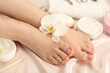 Woman with neat toenails after pedicure procedure on silk fabric, closeup