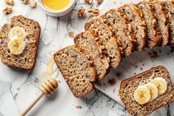 Wall Mural - Peanut Butter Banana bread, sliced, on white gray stone surface shot overhead. Served with honey cinnamon butter.