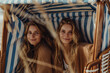 Zwei Frauen genießen eine Auszeit am Strand in einem Strandkorb an der Ostsee
