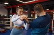 Woman exercising with martial arts trainer practicing self-defense from knife