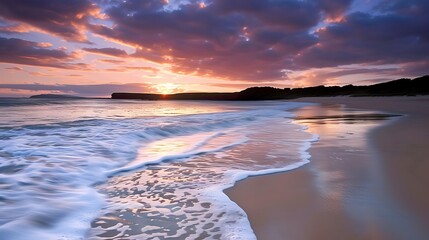 Wall Mural - A serene beach at sunset, with waves gently lapping against the shore.