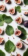 Fresh figs with green leaves on white background. Top view flat lay