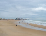 Fototapeta  - Oostende, Belgium - July 31st: Few people on the wide beach during evening hours in nasty weather
