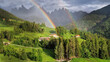 Stunning Alpine scenery of breathtaking Dolomites rocks mountains with double rainbow in Italian Alps, South Tyrol Alto adige , Italy. view of Val di Funes and village Santa Maddalena