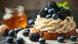  A cake topped with whipped cream and blueberries Nearby, jars of honey and honeycombs