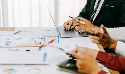 Two people are looking at a graph on a table. One of them is holding a pen. The graph shows a comparison of different data points