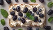   A pristine white plate holds a slice of bread smothered in whipped cream, accompanied by plump blackberries and fragrant mint leaves