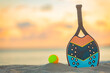 Beach tennis racket. Background with copy space. Sport court at the beach and ball.