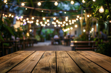 Poster - Wooden table perspective with romantic string lights at an outdoor restaurant