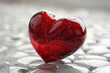 A red glass heart on bright background