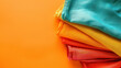 vibrant fabric rolls in a rainbow of colors on orange background, with a copy space for text
